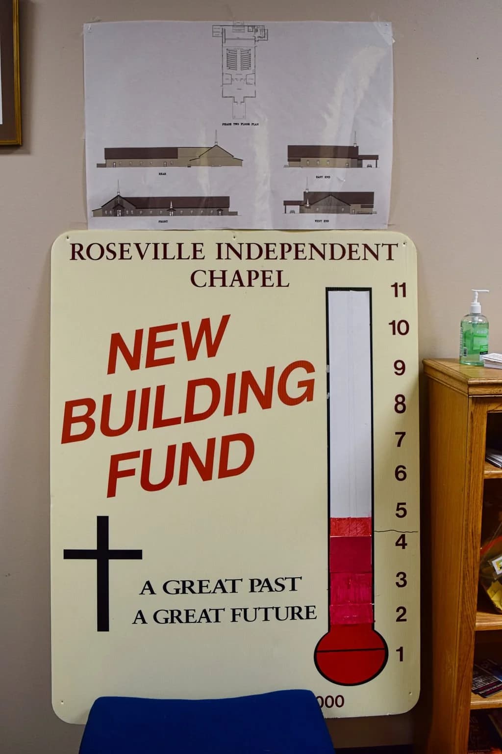 The hand-lettered New Building Fund thermometer sign inside the chapel