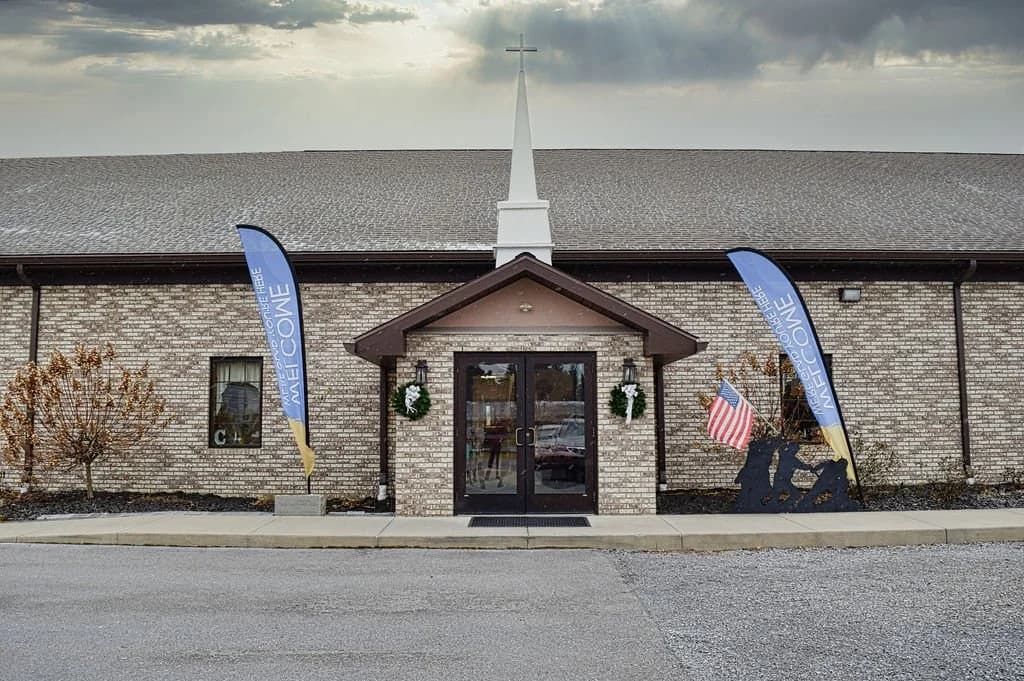 The main entrance under the steeple, wreaths on the doors and banners either side