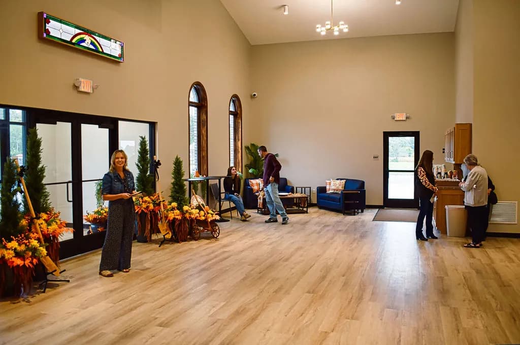 The bright lobby just inside the front doors, fall flowers along the windows