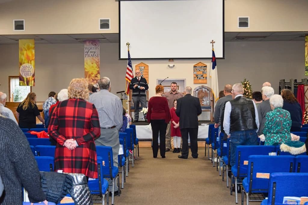The congregation standing in the aisle at the front of the sanctuary