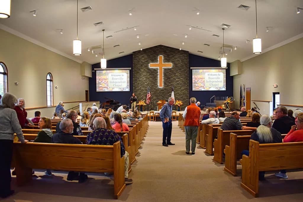 Neighbors catching up in the aisle and pews of the sanctuary before worship, Welcome to Roseville Independent Chapel on both screens