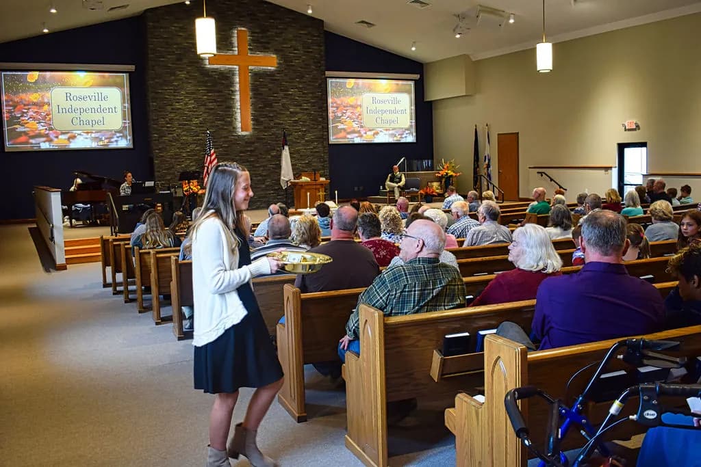 An usher passing the offering plate along the pews