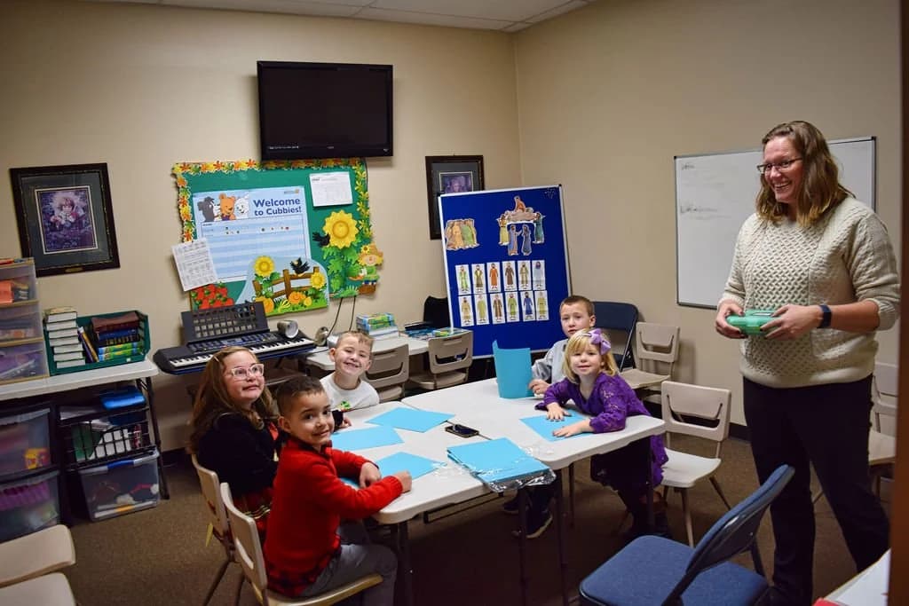 The youngest Sunday School class at work around a table with their teacher