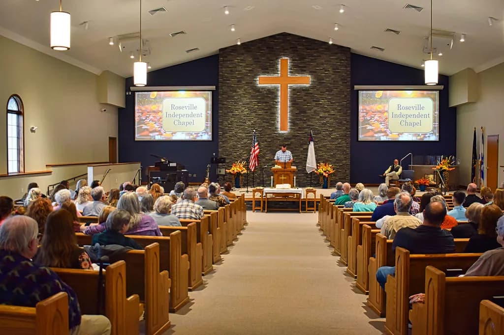 A full Sunday worship service in the new sanctuary at Roseville Independent Chapel, wooden pews on both sides of the center aisle