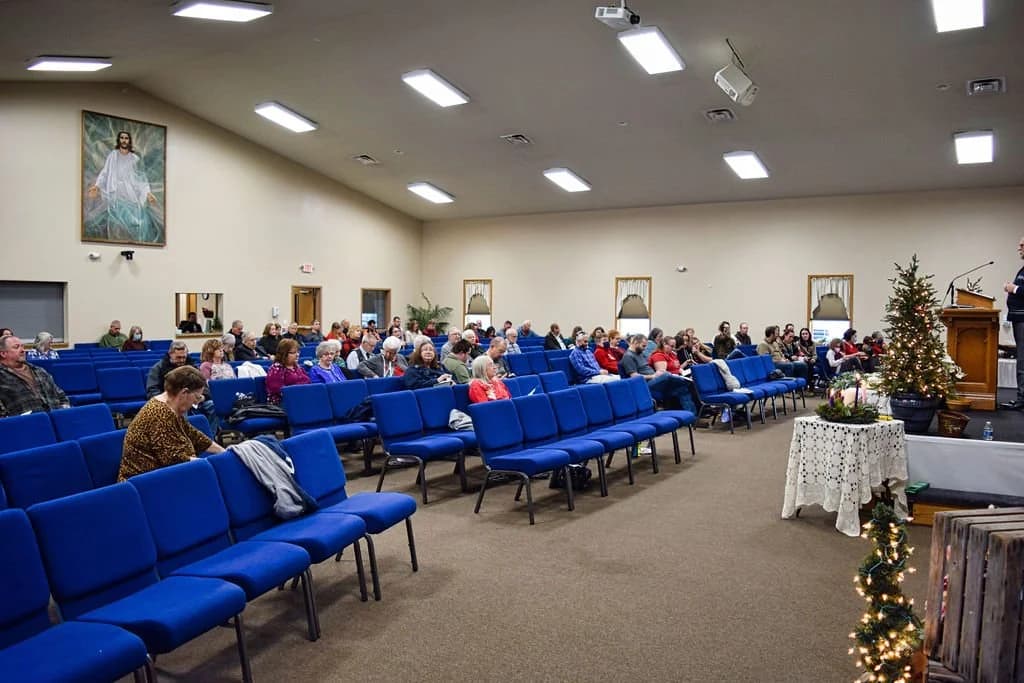 Rows of blue chairs and the congregation seated for worship